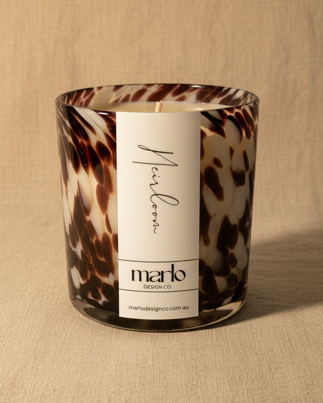Vanilla Caramel Soy Candle with a tortoiseshell pattern and a label on a white surface