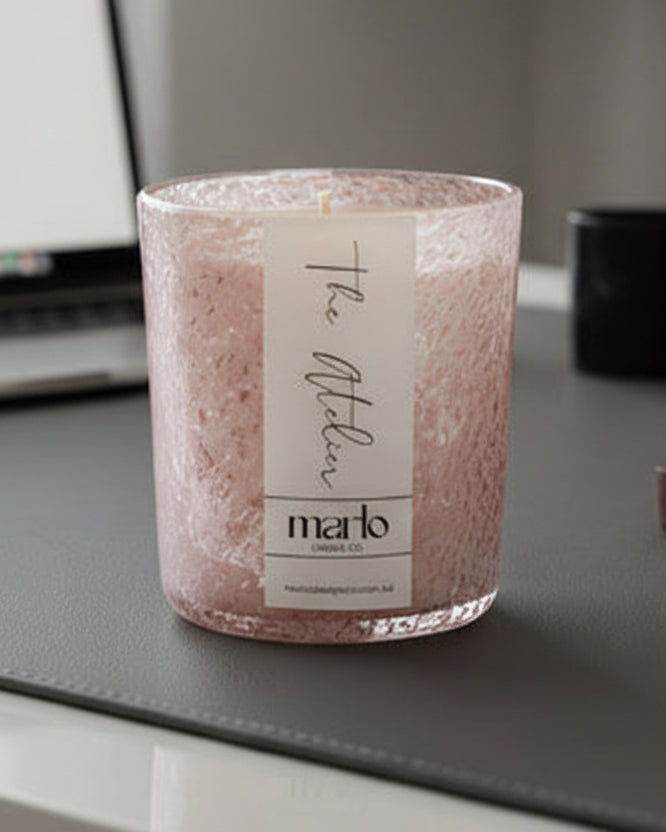 Bourbon and leather scented soy candle in a pink jar